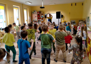Dzieci tańczą z animatorem przy muzyce.